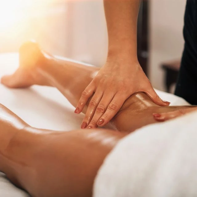 Main massant une jambe